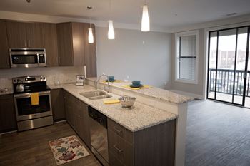 A kitchen with a granite countertop and stainless steel appliances.